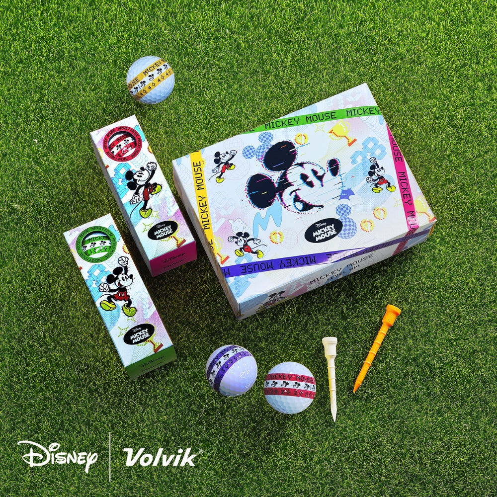 A set of golf balls with Disney Mickey Mouse characters design, along with golf tees and packaging, displayed on a grass-like surface.