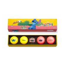 Set of four golf balls with a 'Stitch' design in a branded box on a white background